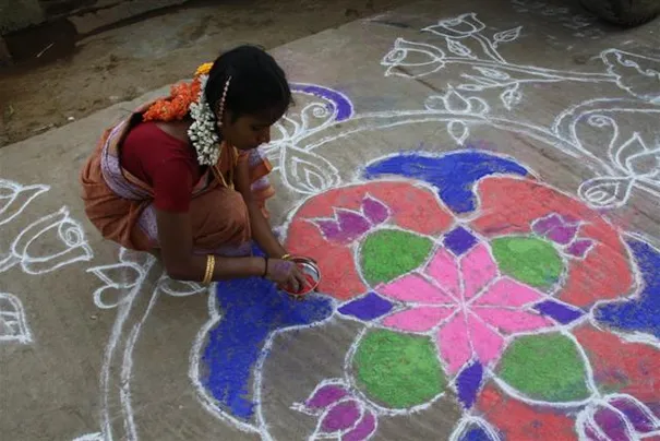 A lady preparing the Pongal decorations on the street, Mamallapuram.